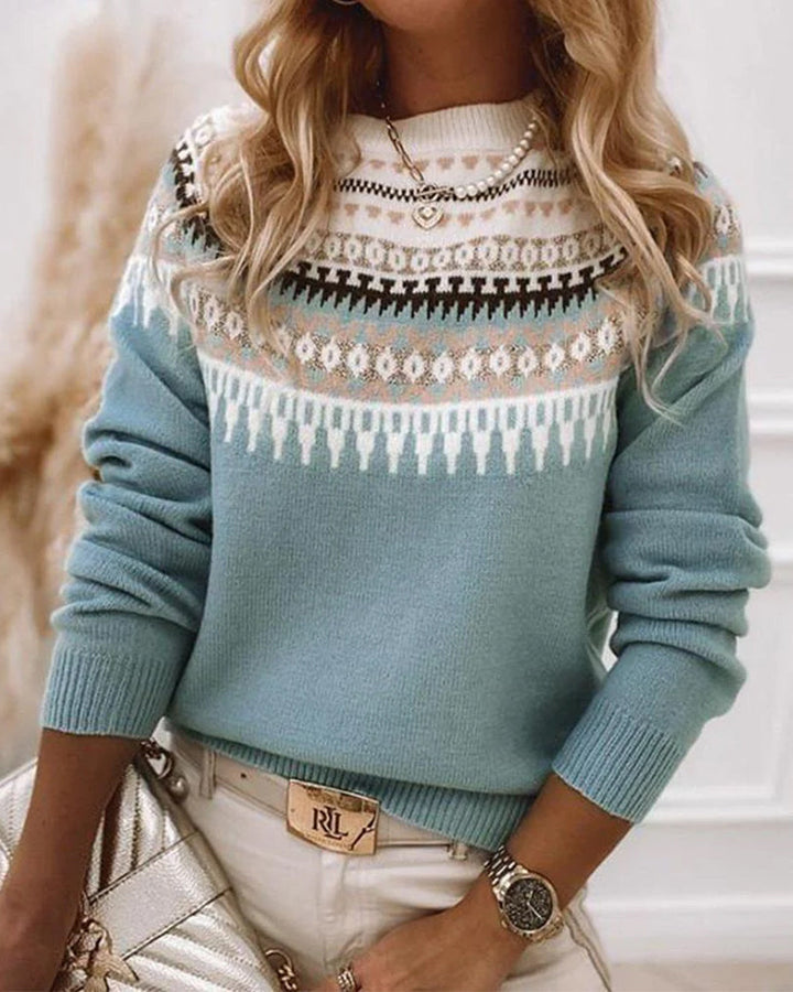 Frau in blauem Norwegerpullover, Strickmuster, Wintermode, eleganter Look, goldene Accessoires.